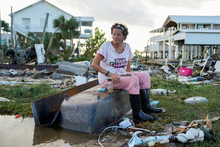 A woman sits amid destruction caused by Hurricane Idalia in Florida, US