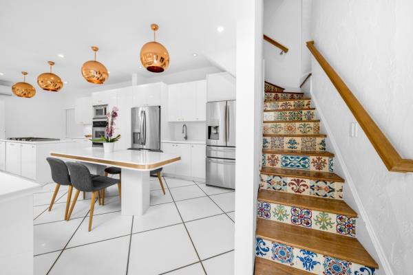 The eat-in chef's kitchen and colorful tiled stairs.