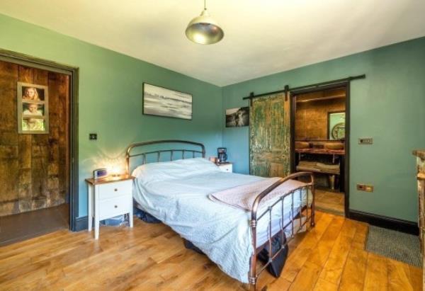 A bedroom in the The Haven with green walls and ensuite bathroom. 