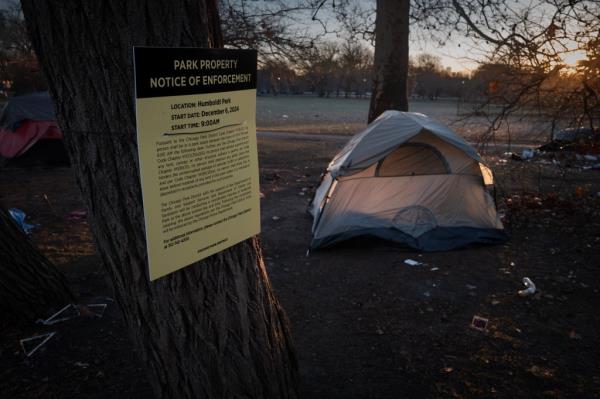 A note in Chicago's Humboldt Park warning residents a<em></em>bout the removal of a tent city.