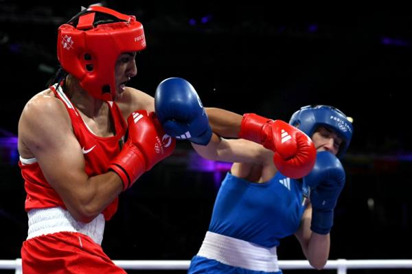 Algeria's Imane Khelif, in red boxing gear, punching Italy's Angela Carini during the women's 66kg boxing match at the Paris 2024 Olympic Games.