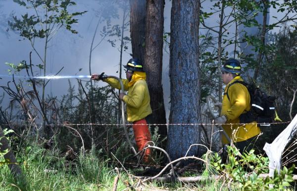 Helicopters were not able to dump water from the sky due to wind gusts and firefighters encountered roadblocks from fallen trees and power lines. 