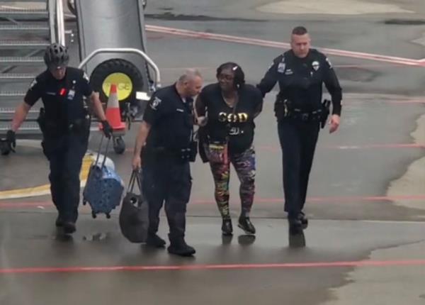 The woman, who is unidentified, was led off the plane by police. 