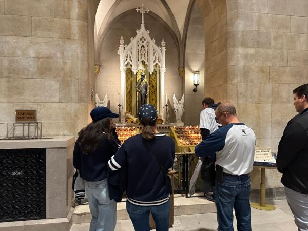 Yankees fans stop in front of a shrine to St. Jude inside St. Patrick's Cathedral ahead of game 3 of the World Series, Monday, Oct. 28, 2024. 