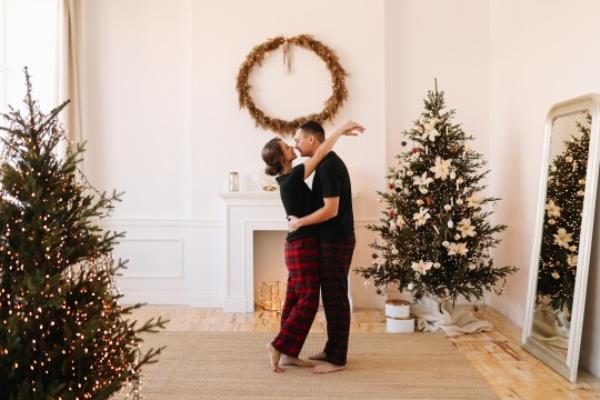 couple kissing in front of christmas tree