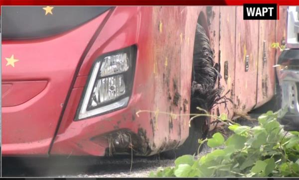 The front of the damaged red bus shows the front driver's side tire shredded.