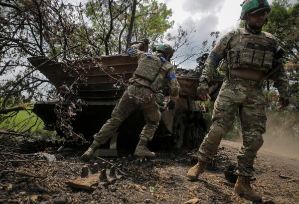 Ukrainian service members check a destroyed Russian a BMP-2 infantry fighting vehicle, amid Russia's attack on Ukraine, near the front line in the newly liberated village Storozheve in Do<em></em>netsk region