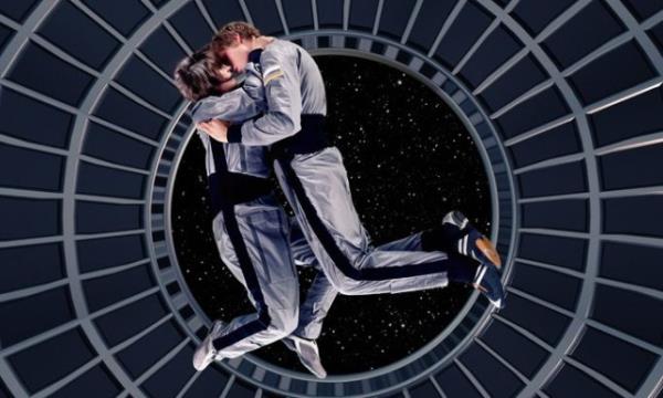 Astro<em></em>nauts locked in an embrace in zero gravity