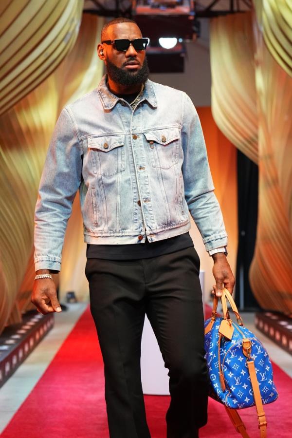 LeBron James walking the red carpet at the 2023 In-Season Tournament Champio<em></em>nship Game, carrying a luxury duffel bag