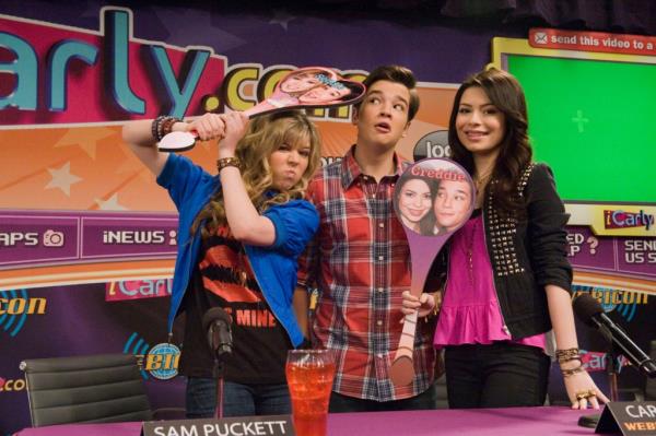 Jennette McCurdy, Nathan Kress and Miranda Cosgrove standing together in front of a table, photo from the TV show 