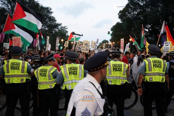 People take part in a protest organized by pro-abortion rights, pro-LGBT rights and pro-Palestinian activists, on the eve of the Democratic Natio<em></em>nal Co<em></em>nvention (DNC), in Chicago, Illinois as Chicago police form a line.  