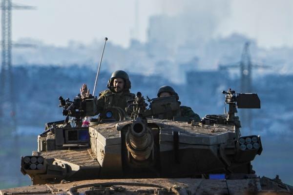 Israeli soldiers driving a tank on the border with Gaza Strip as seen from southern Israel.