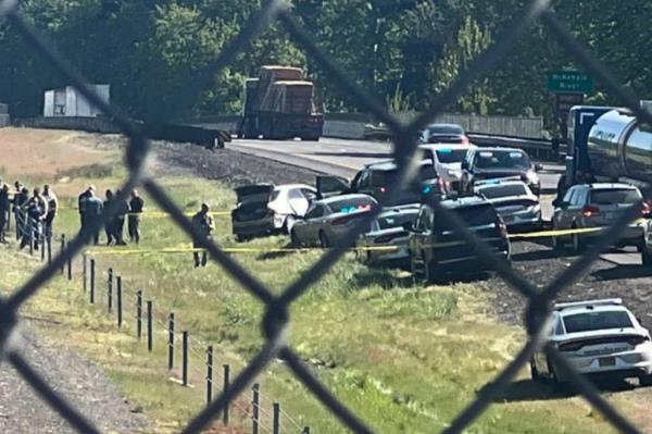 Police officers and cars at a crime scene on Interstate 5, near Eugene, Oregon, wher<em></em>e a former officer was found after a chase, April 23, 2024.