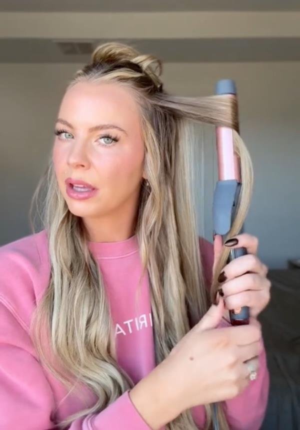 A woman, Mayci Neeley, curling her hair in a style known as 'Utah curls' for TikTok