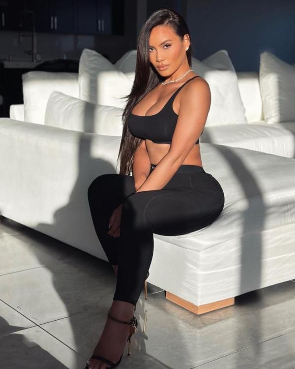 A woman, Daphne Joy, sitting on a couch. 