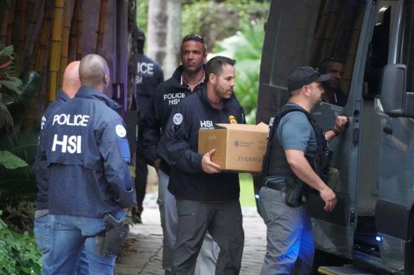 Federal agents carrying boxes of evidence out of Diddy's Miami mansion.