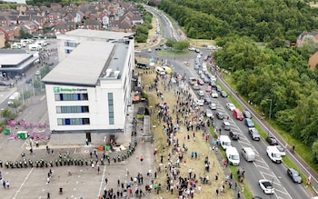 A drone view shows demo<em></em>nstrators protesting outside a hotel as police officers stand guard in Rotherham