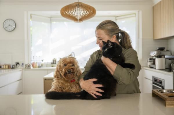 Penny Pedersen with her inside cat Neville and dog, Harvey, at her Ryde home in Sydney. 