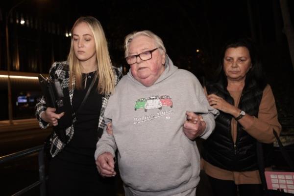 Dick Caine with his lawyer and wife after his arrest in 2022.