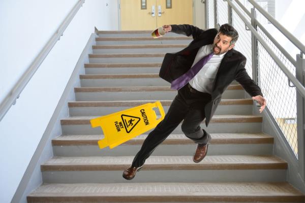 A man holding a phone falling down the stairs.