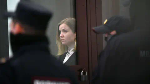 OLGA MALTSEVA/AFP Darya Trepova stands in a courtroom in St Petersburg surrounded by Russian police during her trial in 2023