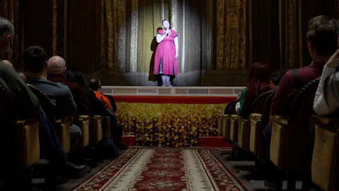 A women stands on stage during a theatre performance in Dnipro